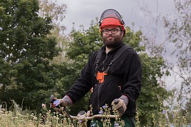 Teilnehmer im Gartenbau mit Mähmaschine