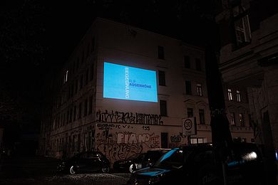 Animationsfilm mit Schlagwort "Begegnung" auf einer Hausfassade