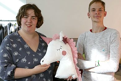 Zwei Auszubildende mit einem selbst genähten Einhorn