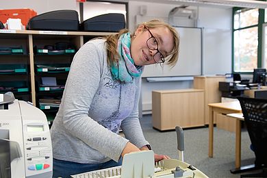 Eine Auszubildende bereitet die Falzmaschine vor