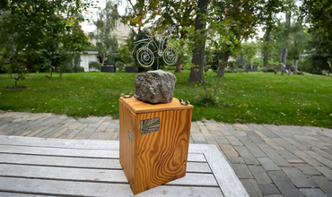 Der Wanderpokal "Drahtesel), eine Holzkiste, auf der ein aus Draht geformtes Fahrrad montiert ist, steht auf einem Tisch.