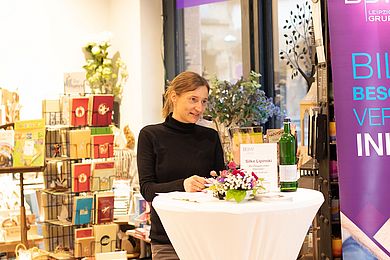 Autorin Silke Lipinski steht an einem Pult vor einem Mikrofon und liest aus ihrem Buch.