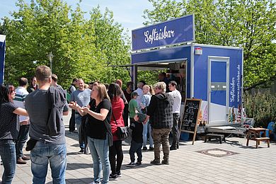 Besucher*innen stehen vorm Softeis-Stand an.