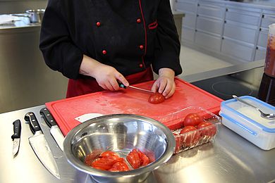 Teilnehmerin in der Hauswirtschaft schneidet Tomaten