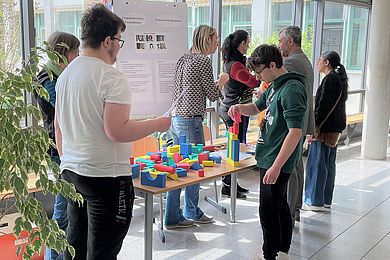 An einem Informationsstand des Logopädischen Fachdienstes liegen viele bunte Formen, die ausprobiert werden können-