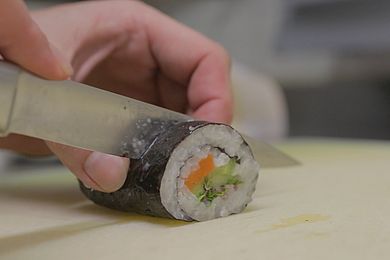 Eine Sushirolle wird durchgeschnitten.