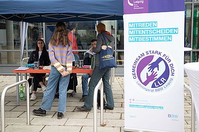 An einem Informationsstand sind Mitglieder des Lehrlingsrates mit Interessierten im Gespräch.