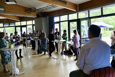 Ira Kummrow und Thomas Rusch werden von hinten mit Blick auf die Teilnehmenden der Podiumsdiskussion im Freizeithaus gezeigt. 